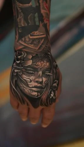 Tatuaj cu portret feminin pe dosul mâinii