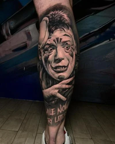 Tatuaj realist cu portret și mână pe gambă