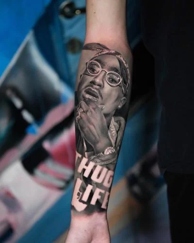 Tatuaj realist cu portret și text pe antebraț