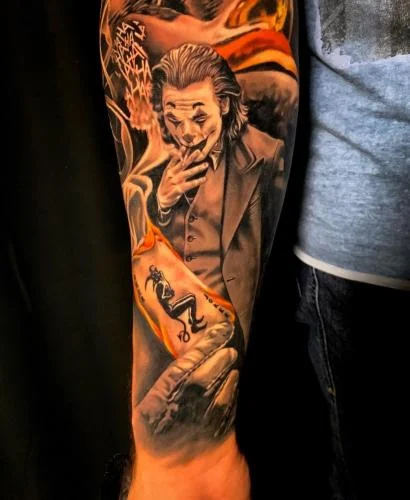 Tatuaj color pe antebraț cu un personaj în costum