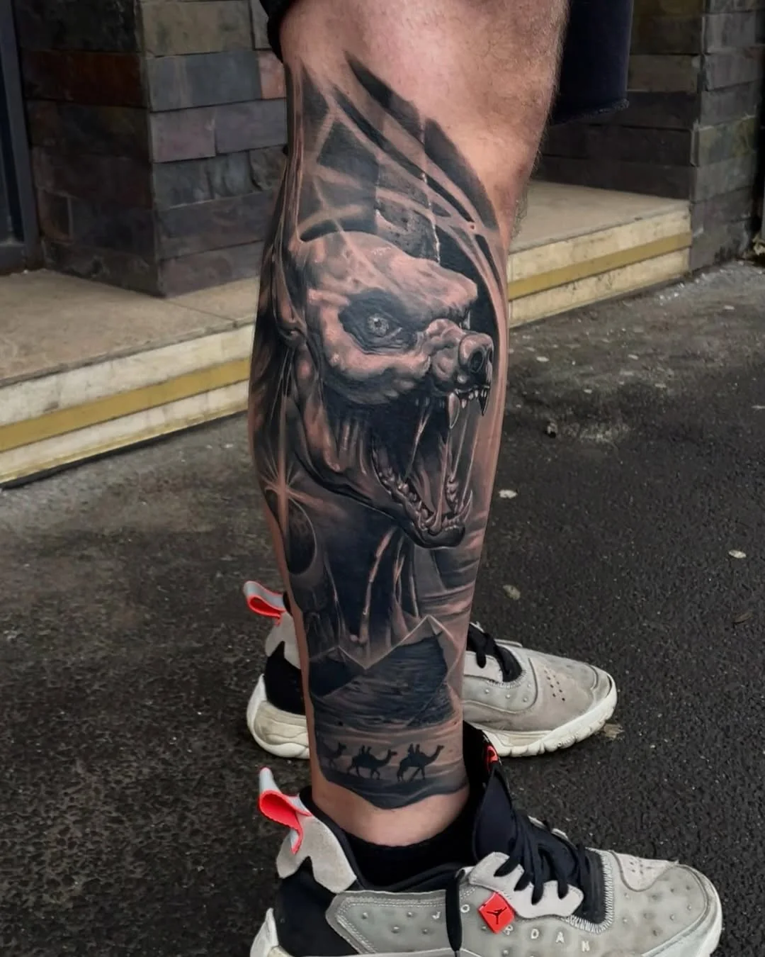 Tatuaj realist black and grey cu creatură pe gambă