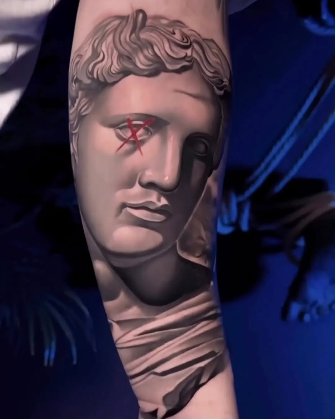 Tatuaj realist cu cap de statuie antică pe antebraț