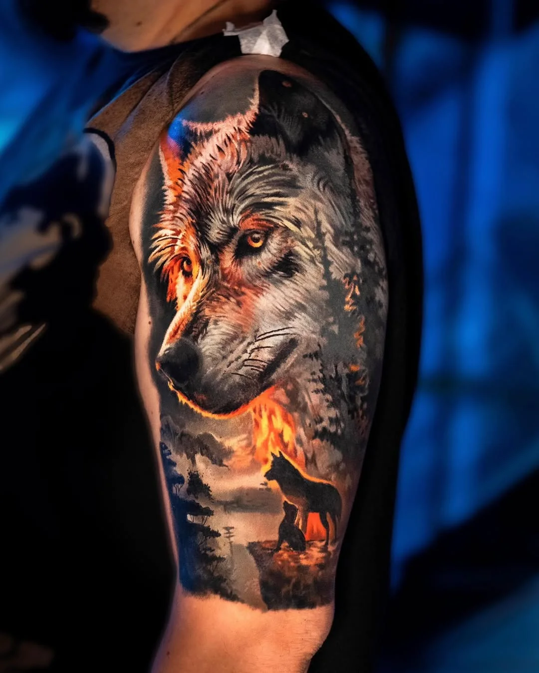 Tatuaj color realist cu lup într-un peisaj de pădure pe umăr