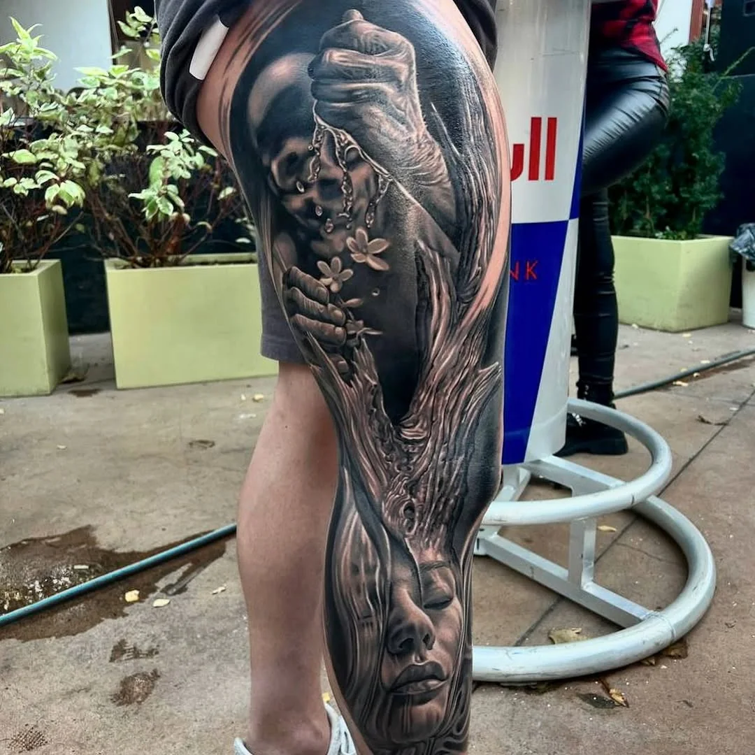 Tatuaj realist black and grey cu chipuri pe picior