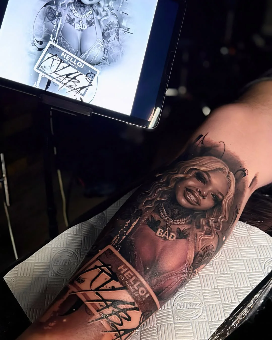 Tatuaj realist cu portret de femeie și text pe antebraț