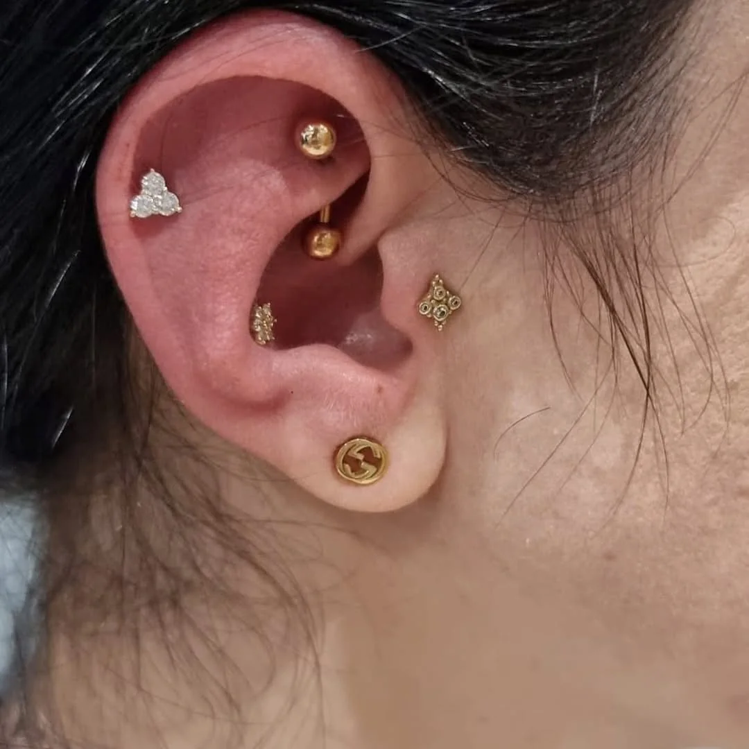 Piercing multiplu în ureche cu bijuterii aurii